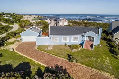 an aerial view of a house with the ocean at Mocha Bay House by the Sea in Bettyʼs Bay