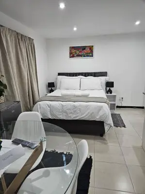 a bedroom with a bed and a glass table at Cozy Private Studio in Cape Town