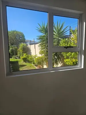 a window with a view of a palm tree at Cozy Private Studio in Cape Town