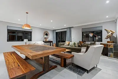a living room with a wooden table and chairs at Flamingo Bay Manor in Fisherhaven