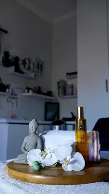 a table with a bottle of oil and flowers on it at Somerset Wineland Apartments & Wellness in Somerset West