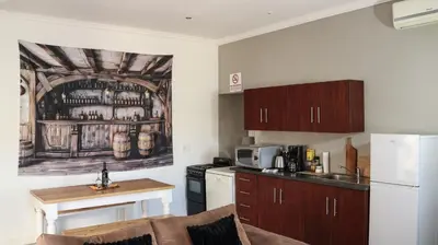 a kitchen with a white refrigerator and a table at Somerset Wineland Apartments & Wellness in Somerset West
