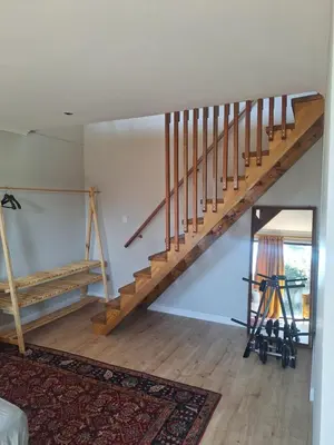 a living room with a wooden staircase in a house at Governor's nest in Cape Town