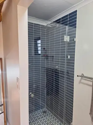 a bathroom with a shower with blue tiles at Governor's nest in Cape Town