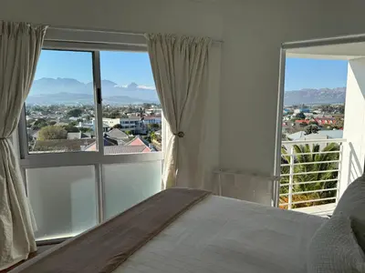 a bedroom with a bed and a large window at Clouds in Strand