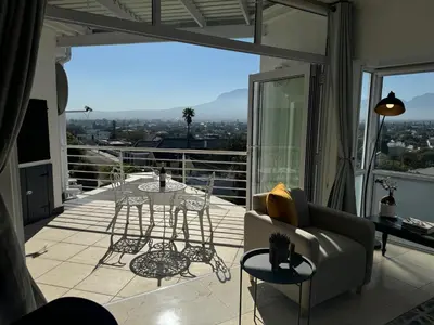 a living room with a balcony with a view at Clouds in Strand
