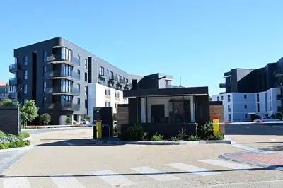 a building in the middle of a street with buildings at BGS Luxury -Two-bed -Nine Palms in Cape Town