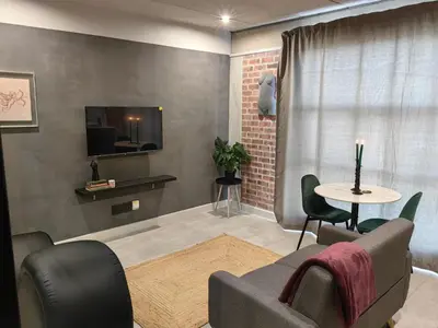 a living room with a couch and a table at Ultra-Modern Studio Apartment in Table View