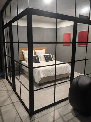 a room with a bed inside of a glass wall at Ultra-Modern Studio Apartment in Table View