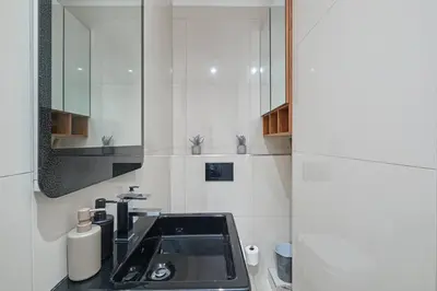a bathroom with a sink and a mirror at Modern Cape Town Beach Apartment in Cape Town