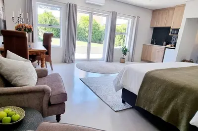 a bedroom with a bed and a living room at C'est la Vie 1 in Franschhoek