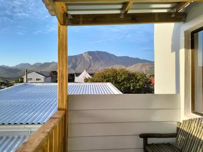 a balcony with a view of the mountains at C es Cape in Pringle Bay