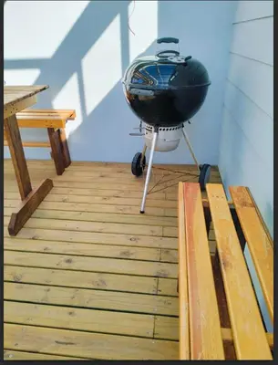 a grill sitting on a stand on a wooden floor at C es Cape in Pringle Bay
