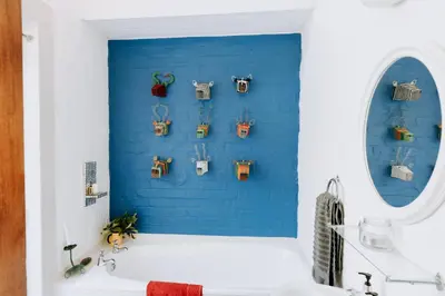 a bathroom with a blue wall and a white tub at little villa in the vineyard in Stellenbosch