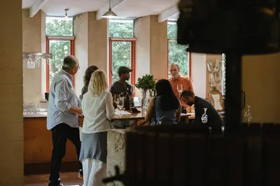 a group of people standing around a bar at little villa in the vineyard in Stellenbosch