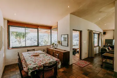 a dining room with a table and some windows at little villa in the vineyard in Stellenbosch