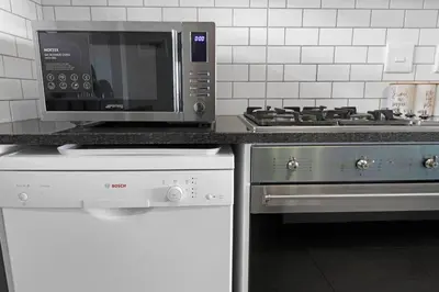 a microwave oven and a stove in a kitchen at Two Bedroom Luxury Apartment, Century City - BackUp Power in Cape Town