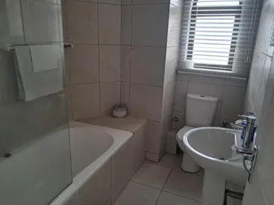 a bathroom with a tub and a toilet and a sink at 8 Marina Sands beach apartment in Cape Town