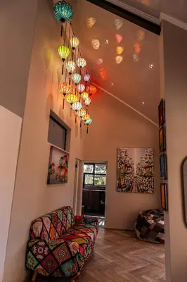 a living room with a couch and chandeliers at The Glass Castle Retreat in Sir Lowry Pass