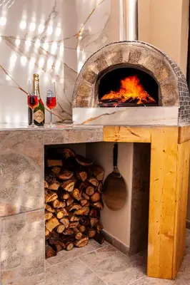 a wood fired pizza oven with fire in it at The Glass Castle Retreat in Sir Lowry Pass