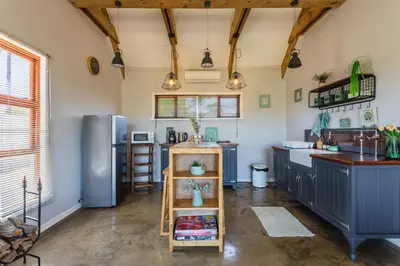a kitchen with blue cabinets and a stainless steel refrigerator at Hephzibah Inn River Cabin in Hermon