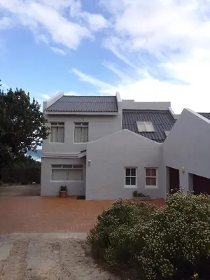 a white house with a black roof at Heaven's Door in Bettyʼs Bay