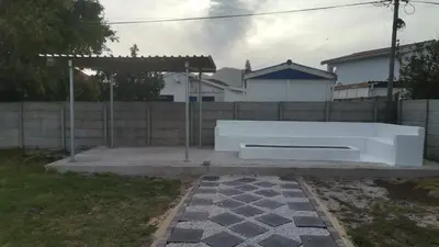 a white bench sitting in a yard next to a fence at Shekinah at Sea in Kleinmond