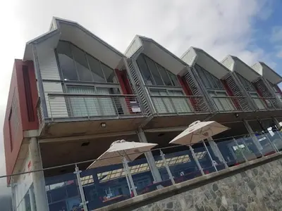 a building with umbrellas in front of it at Shekinah at Sea in Kleinmond