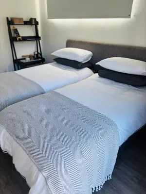 two beds sitting next to each other in a room at Hermanus Garden Studios in Hermanus