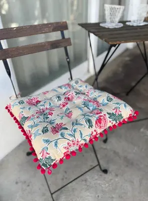 a chair with a floral seat with a table at Hermanus Garden Studios in Hermanus