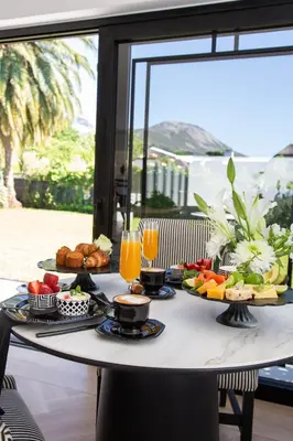 a breakfast table with food and drinks on a balcony at Coco Queen in Paarl