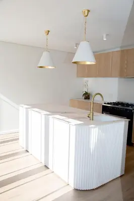 a kitchen with a white island with a sink at Coco Queen in Paarl