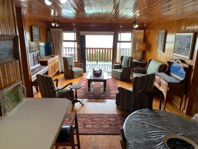 a living room filled with furniture and a table at Bay View Cabin in Gordonʼs Bay