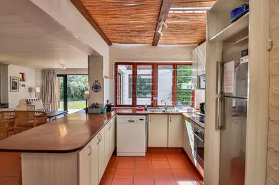 a large kitchen with a large island in a room at Hilbre House in Bettyʼs Bay