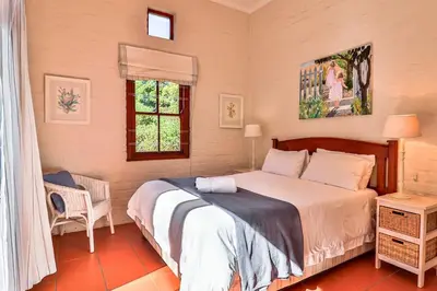 a bedroom with a bed and a window at Hilbre House in Bettyʼs Bay