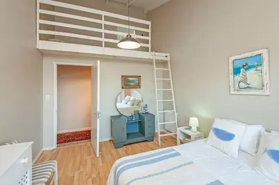 a bedroom with a bunk bed and a mirror at Whispering Waves in Hermanus