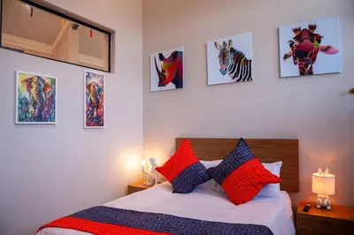 a bedroom with a bed with red and blue pillows at Serenity Vista Retreat in Cape Town
