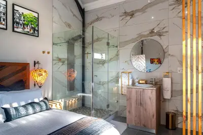 a bedroom with a glass shower and a bed at Serenity Vista Retreat in Cape Town