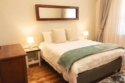 a bedroom with a bed with a mirror on the wall at The View Guesthouse & Cottage in Caledon
