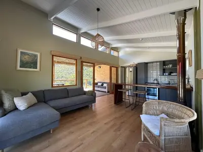 a living room with a couch and a table at The River Retreat Kogelberg in Kleinmond