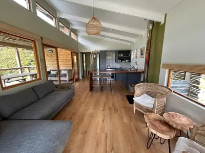 a living room with a couch and a table at The River Retreat Kogelberg in Kleinmond