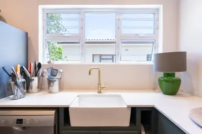 a kitchen counter with a sink and a window at Coastal Elegant 4 Bedroom Home in Hermanus
