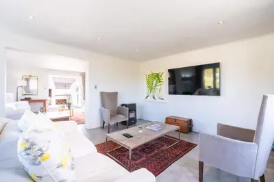 a living room with a white couch and a table at Coastal Elegant 4 Bedroom Home in Hermanus