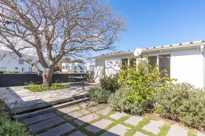 a house with a tree in the yard at Coastal Elegant 4 Bedroom Home in Hermanus