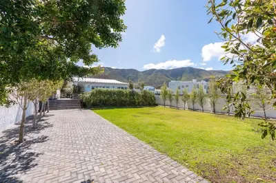 a garden with a brick pathway and grass at Coastal Elegant 4 Bedroom Home in Hermanus