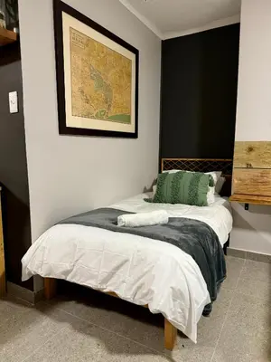 a bedroom with two beds and a picture on the wall at Stones - Cape Town Self Catering in Cape Town