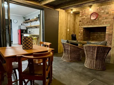 a dining room with a table and chairs and a fireplace at Stones - Cape Town Self Catering in Cape Town