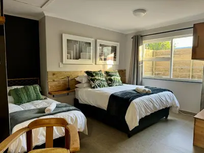 a bedroom with two beds and a window at Stones - Cape Town Self Catering in Cape Town