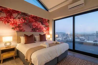 a bedroom with a large bed with a large window at Penthouse with a view to die for! in Cape Town