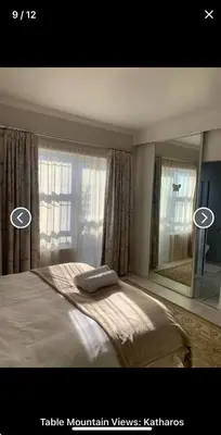 a bedroom with a large bed and a mirror at Table Mountain Views in Cape Town